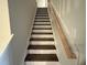 Wooden staircase with a light-colored handrail, leading to the upper level at 145 Green Haven Blvd # 83, Youngsville, NC 27596