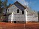 Side view of house under construction, brick foundation, house wrap at 1207 Red Cedar Court, Youngsville, NC 27596