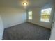 A bright bedroom with neutral carpet and two windows allowing natural light to illuminate the space at 1504 Maelyn Way, Fuquay Varina, NC 27526