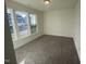 A vacant bedroom has three large windows that provide natural light, and neutral carpet at 1504 Maelyn Way, Fuquay Varina, NC 27526