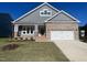 Charming home with a brick and gray siding facade, a two-car garage, and a beautifully landscaped front yard at 1504 Maelyn Way, Fuquay Varina, NC 27526
