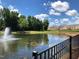 Scenic view of a community pond with a fountain, surrounded by lush trees and well-maintained landscaping at 1504 Maelyn Way, Fuquay Varina, NC 27526