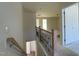 Bright staircase with stained wood banister and iron spindles leading to an upper floor hallway and bedroom entrances at 1504 Maelyn Way, Fuquay Varina, NC 27526