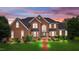 Stunning brick home with lush landscaping, arched windows, and walkway at 4600 Scottland Dr, Mebane, NC 27302