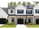 Charming townhome with white siding, black shutters, stone accents, and well-manicured lawn at 727 Putney Hill Rd, Zebulon, NC 27597