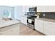 Modern kitchen with stainless steel appliances, gray backsplash, quartz counters, and ample cabinet space at 727 Putney Hill Rd, Zebulon, NC 27597