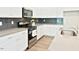 Contemporary kitchen with stainless steel appliances, gray backsplash and countertops, and bright white cabinets at 727 Putney Hill Rd, Zebulon, NC 27597
