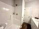 White shower and vanity and modern fixtures in a well-lit bathroom at 215 Britt St, Smithfield, NC 27577
