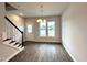 Well-lit dining area with a modern chandelier, staircase access, and a view to the yard at 215 Britt St, Smithfield, NC 27577