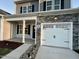 Front view of a two-story house with a white garage door and stone accents at 215 Britt St, Smithfield, NC 27577