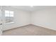 A bright bedroom with carpet, a large window, and neutral walls is bathed in natural light at 490 Oak Park Blvd, Youngsville, NC 27596