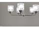 Close up of a brushed-nickel chandelier with five glass shades at 490 Oak Park Blvd, Youngsville, NC 27596