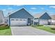 Home featuring a two-car garage, charming blue siding and a well-manicured lawn at 1304 Jasmine View Way, Knightdale, NC 27545