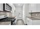A bright kitchen boasts stainless steel appliances, white cabinetry and modern backsplash at 1304 Jasmine View Way, Knightdale, NC 27545