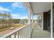 Cozy balcony with a view to the house, car in the driveway, and lush green trees at 80 Bold Dr, Youngsville, NC 27596