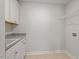 Well-lit laundry area featuring upper cabinets and granite countertops at 80 Bold Dr, Youngsville, NC 27596