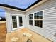 A charming covered back patio featuring a sliding glass door entry and large picture window at 1056 Fairhaven Dr # 97, Mebane, NC 27302