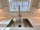 Close up of the kitchen sink with stone countertops and tile backsplash under a window at 1056 Fairhaven Dr # 97, Mebane, NC 27302
