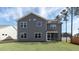The backyard showcases the home's gray siding, various window views, and a screened patio at 1237 Jasmine View Way, Knightdale, NC 27545
