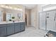 Modern bathroom with double vanity, framed mirrors, walk-in glass shower, and marble-style tile at 512 Lemon Daisy Ln, Knightdale, NC 27545