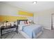 Comfortable bedroom featuring desk and decor with yellow accent wall, carpeted floors, and a cozy ambiance at 512 Lemon Daisy Ln, Knightdale, NC 27545