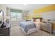 Cozy bedroom with a grey bed, modern decor, natural light, and yellow accent band on the wall at 512 Lemon Daisy Ln, Knightdale, NC 27545