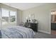Comfortable bedroom with a large window, black dresser, soft chair, and view to a gray toned ensuite bathroom at 512 Lemon Daisy Ln, Knightdale, NC 27545