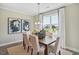 Elegant dining room features a wooden table, comfortable seating, a stylish light fixture, and natural light at 512 Lemon Daisy Ln, Knightdale, NC 27545