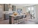 Modern kitchen with gray cabinets, stainless steel appliances, quartz countertops, and an island with seating at 512 Lemon Daisy Ln, Knightdale, NC 27545