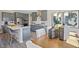 Modern kitchen featuring an island with bar stool seating, gray cabinetry, stainless steel appliances, and a dining area at 512 Lemon Daisy Ln, Knightdale, NC 27545