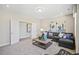 Open living room with neutral walls, a gray sofa, and a view into the adjacent hall at 512 Lemon Daisy Ln, Knightdale, NC 27545