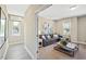 Bright living room with modern decor, large windows, and a comfortable gray sectional sofa at 512 Lemon Daisy Ln, Knightdale, NC 27545