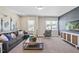 Cozy living room boasts a comfortable sectional sofa, stylish decor, large windows, and a contemporary entertainment center at 512 Lemon Daisy Ln, Knightdale, NC 27545