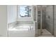 Bright bathroom with a tub, tiled shower, and large window, offering a spa-like experience and natural light at 524 Lemon Daisy Ln, Knightdale, NC 27545