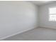 Well-lit bedroom with a large window, carpet flooring, and neutral walls, creating a comfortable living space at 524 Lemon Daisy Ln, Knightdale, NC 27545