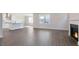 Open-concept living room with hardwood floors, fireplace, and view into modern kitchen at 524 Lemon Daisy Ln, Knightdale, NC 27545