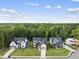 Aerial view showcases three modern homes with lush landscaping backing up to a forest at 205 Red Cardinal Ct, Youngsville, NC 27596