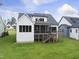 Backyard view of a home with a screened porch, wooden deck, and a lush green lawn at 205 Red Cardinal Ct, Youngsville, NC 27596