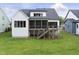 Backyard view of a home with a screened porch, wooden deck, and a lush green lawn at 205 Red Cardinal Ct, Youngsville, NC 27596