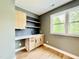 Stylish bar area featuring custom cabinets, open shelving, and large windows for natural light at 205 Red Cardinal Ct, Youngsville, NC 27596