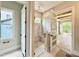 Walk-in shower with glass door and bench with view of the vanity and open doorway at 205 Red Cardinal Ct, Youngsville, NC 27596