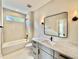 Modern bathroom with a large vanity, a bathtub-shower combo, and neutral tile at 205 Red Cardinal Ct, Youngsville, NC 27596