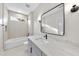 Bright bathroom with a double vanity with marble counter, a soaking tub, and modern lighting at 205 Red Cardinal Ct, Youngsville, NC 27596