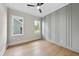 Bedroom features wood accent wall, hardwood floors, and a pair of windows providing natural light at 205 Red Cardinal Ct, Youngsville, NC 27596