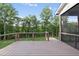 Wooden deck area overlooks the grassy backyard and wooded area; features railing and steps down at 205 Red Cardinal Ct, Youngsville, NC 27596