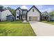 New two-story construction home with modern farmhouse design, detailed trim, and a lush manicured lawn at 205 Red Cardinal Ct, Youngsville, NC 27596