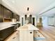 Open-concept kitchen with marble countertops, dark cabinetry, wood island, and hardwood flooring at 205 Red Cardinal Ct, Youngsville, NC 27596