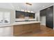 A modern kitchen featuring a large island, stainless steel appliances, and designer lighting at 205 Red Cardinal Ct, Youngsville, NC 27596