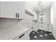 Laundry room featuring custom cabinets, marble countertops, modern fixtures, and stylish black and white flooring at 205 Red Cardinal Ct, Youngsville, NC 27596
