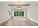 Spacious living room showcasing hardwood floors, exposed beam, modern light fixture, and access to outdoor deck at 205 Red Cardinal Ct, Youngsville, NC 27596